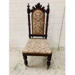 Oak carved hall chair with turned finials on brass castors