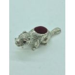 A silver pincushion in the form of a beaver with ruby eyes