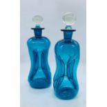 Two blue decorative are decanters with clear stoppers