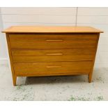 A wide oak mid century three drawer chest of drawers (H83cm W128cm D47cm