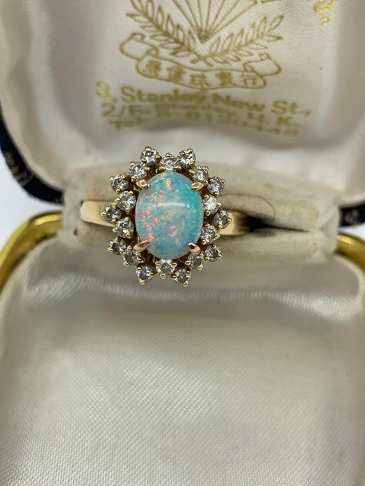 An opal and diamond cluster ring set with twenty diamonds.