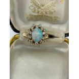 An opal and diamond cluster ring set with twenty diamonds.