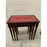Nest of red leather topped mahogany tables