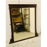 A large wood over mantle framed bevelled mirror (132cm x 126cm)