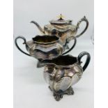 A white metal teapot, milk jug and sugar bowl