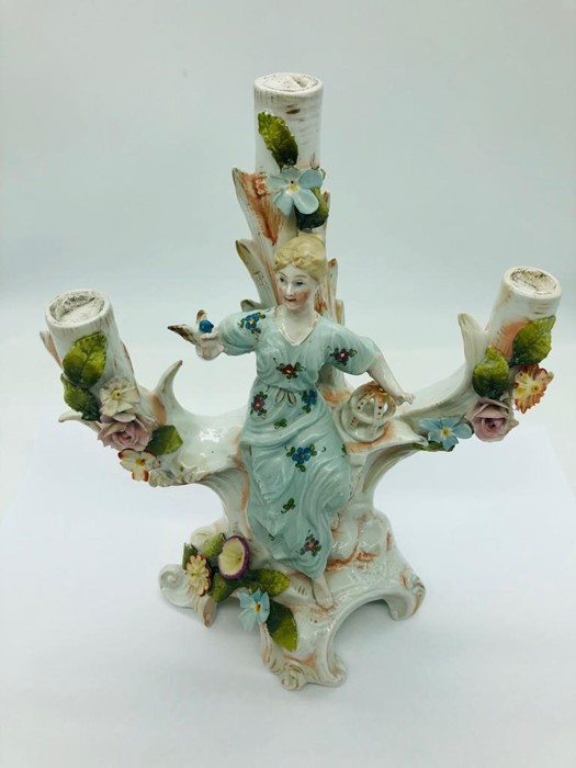 A Dresden three branched candle holder adorned with a lady and bird