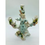 A Dresden three branched candle holder adorned with a lady and bird