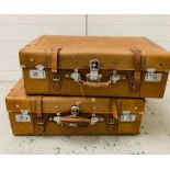 Two vintage canvas luggage cases with buckled straps