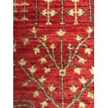 An Large red ground hand knotted rug with diamond blue and white border AF(274CM X 183CM)