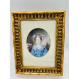A framed miniature of a lady in a blue dress with flowers in her hair.