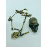 A brass cased albert style chain with skull vesta ABD T bar