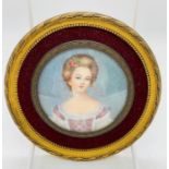 An round framed miniature of a lady, signed PA.