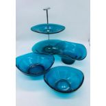 Four pieces of decorative art glass in turquoise blue including cake plate and dishes