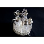Victorian Cruet set Comprises a sterling silver stand and five condiment crystal bottles with silver