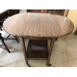 An oval drop leaf table/drinks trolley on castors