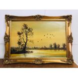 A Gilt framed oil on canvas of ducks flying over a lake