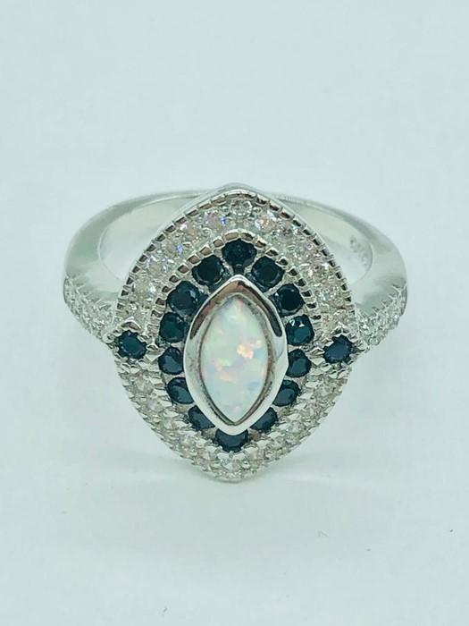 A silver art deco style ring set with sapphires cz's and central opal panel