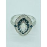 A silver art deco style ring set with sapphires cz's and central opal panel