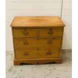 A small pine chest of drawers two over two with brass drop handles