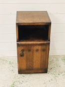 A small bedside cabinet in arts and crafts style