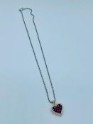 A Heart shaped pendant central rubies with diamond surround on a 14ct mount with an 18ct chain.