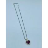 A Heart shaped pendant central rubies with diamond surround on a 14ct mount with an 18ct chain.