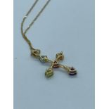 A pendant in cross form with semi precious stones to include aquamarine, peridot, ruby, amethyst and