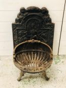 A decorative cast iron fire basket with back plate