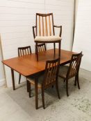 An extendable mid century dining table by McIntosh with five G plan dining chairs to include one