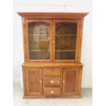 A large pine dresser with glass doors, shelves, cupboards and three drawers (H198cm D42cm W144cm)