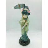A Lladro figure of an oriental lady holding an open parasol and a closed fan