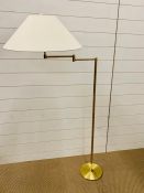 A single light swing arm floor lamp in bronze finish with cream shade