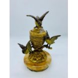 A cold painted bronze inkwell on a marble stand featuring three nesting lovebirds in the manner of