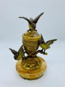 A cold painted bronze inkwell on a marble stand featuring three nesting lovebirds in the manner of