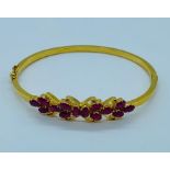 A 22ct yellow gold bracelet, made up fourteen rubies with a floral theme. (11.5g)