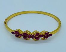 A 22ct yellow gold bracelet, made up fourteen rubies with a floral theme. (11.5g)