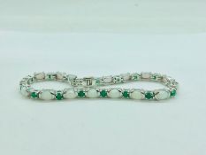 A silver line bracelet set with emerald and opal panels