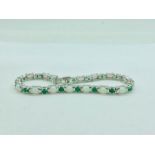 A silver line bracelet set with emerald and opal panels