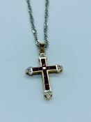 A ruby and diamond cross in a 9ct setting on a 9ct chain