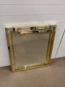 A geometric design square brass framed mirror