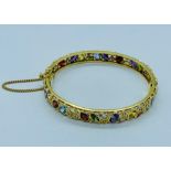 An 18ct yellow gold bracelet set with a variety of precious and semi precious stones in a variety of