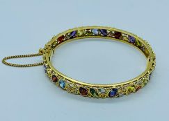 An 18ct yellow gold bracelet set with a variety of precious and semi precious stones in a variety of