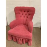 A low pink button back bedroom chair
