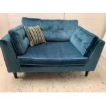 A love chair in velvet teal button back