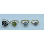 Four 9ct gold rings with a selection of settings and styles to include rubies, diamonds and peridot.