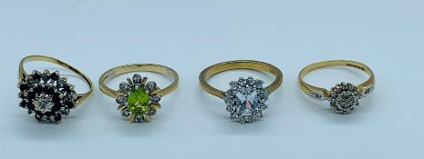 Four 9ct gold rings with a selection of settings and styles to include rubies, diamonds and peridot.