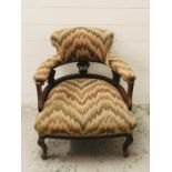 An upholstered open armchair with cabriole legs