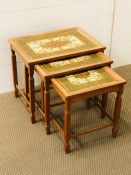 A nest of three tiled topped tables