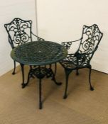 A round metal garden table with two chairs