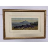A Framed print of a mountain scene signed by Alfred Grahame